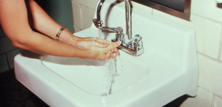 a person washing their hands in a sink