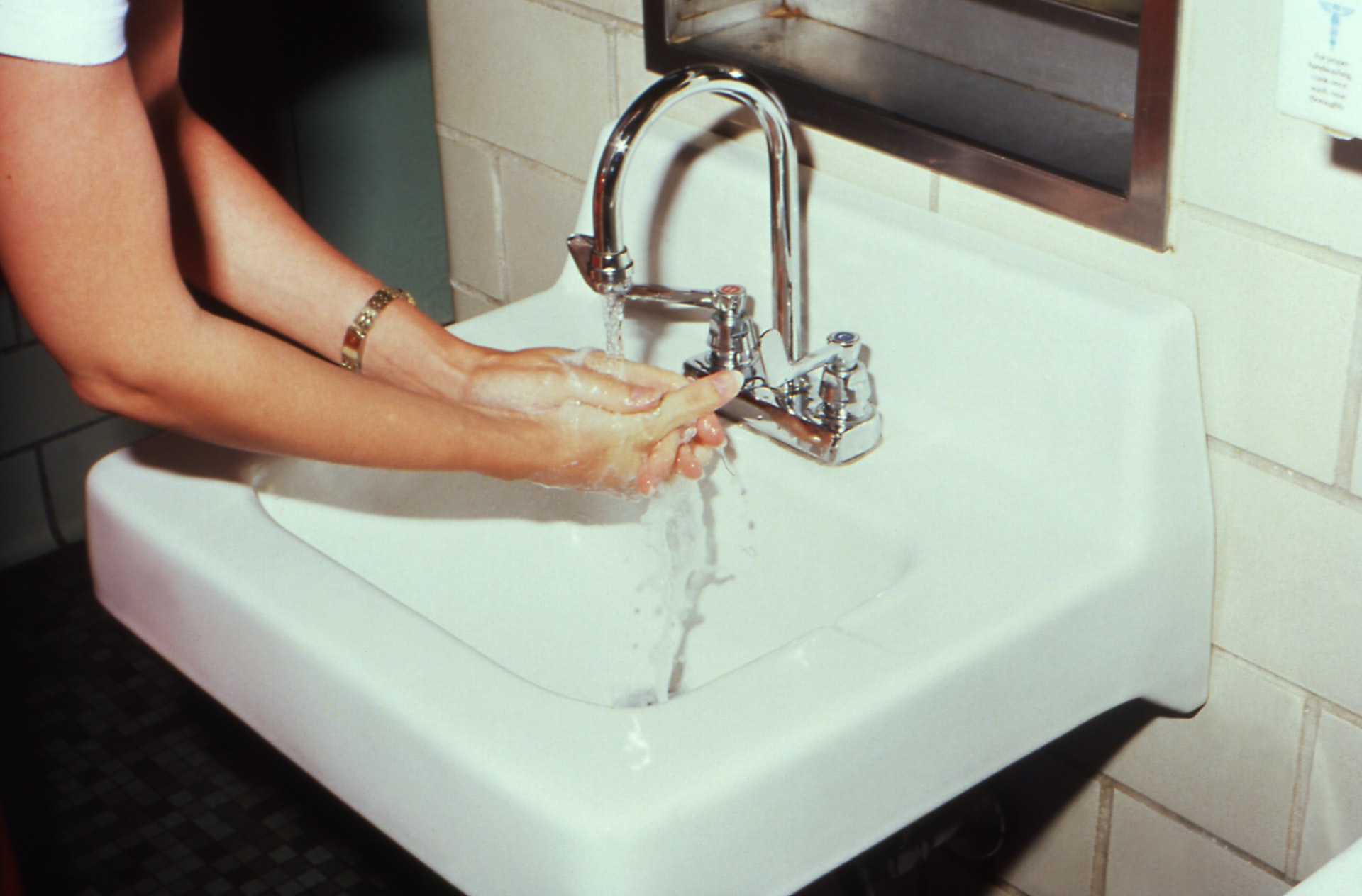 a person washing their hands in a sink