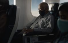 a man wearing a face mask sitting in a plane