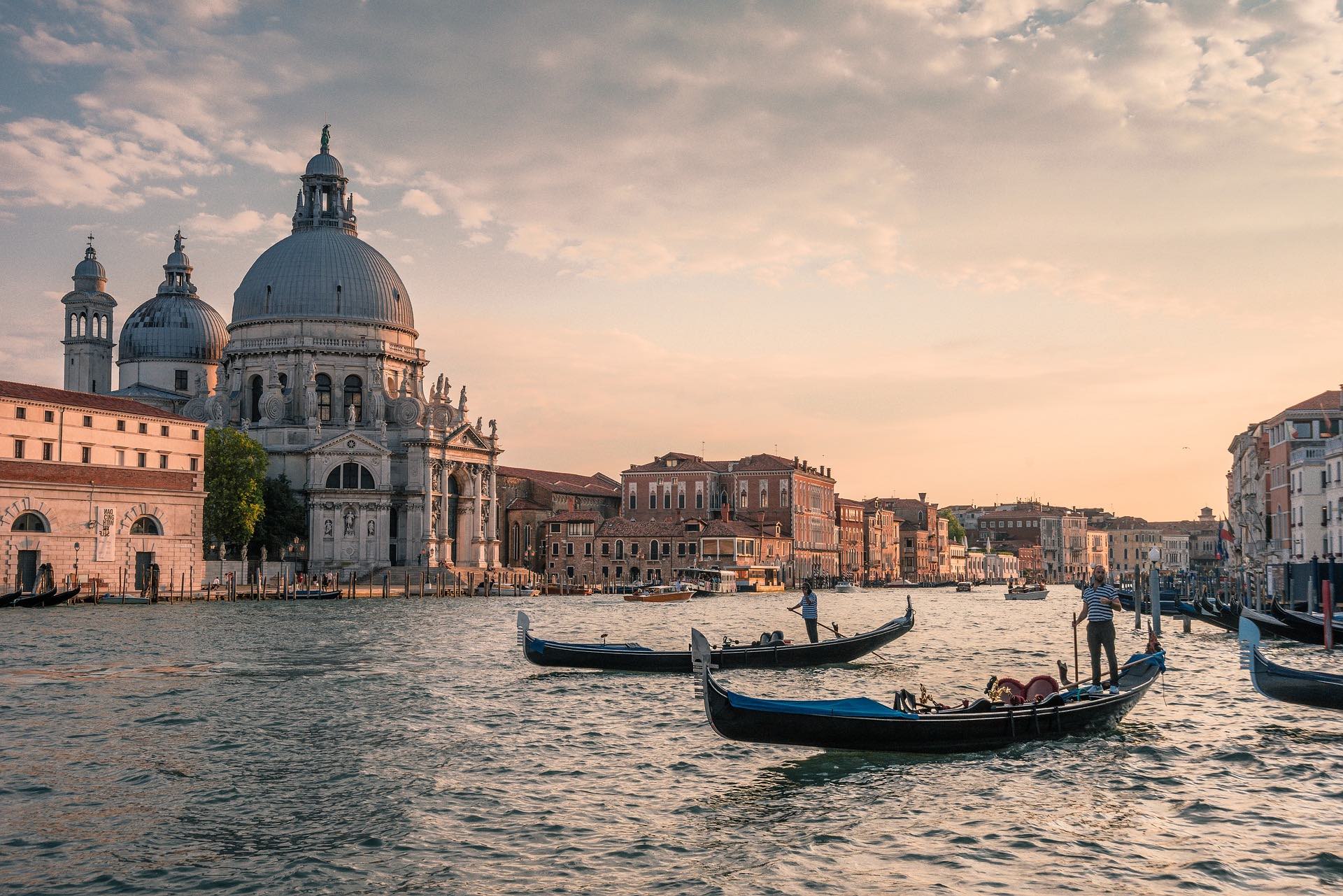 a group of people on a boat in a body of water with a dome in the background