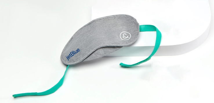a grey eye mask with a green strap