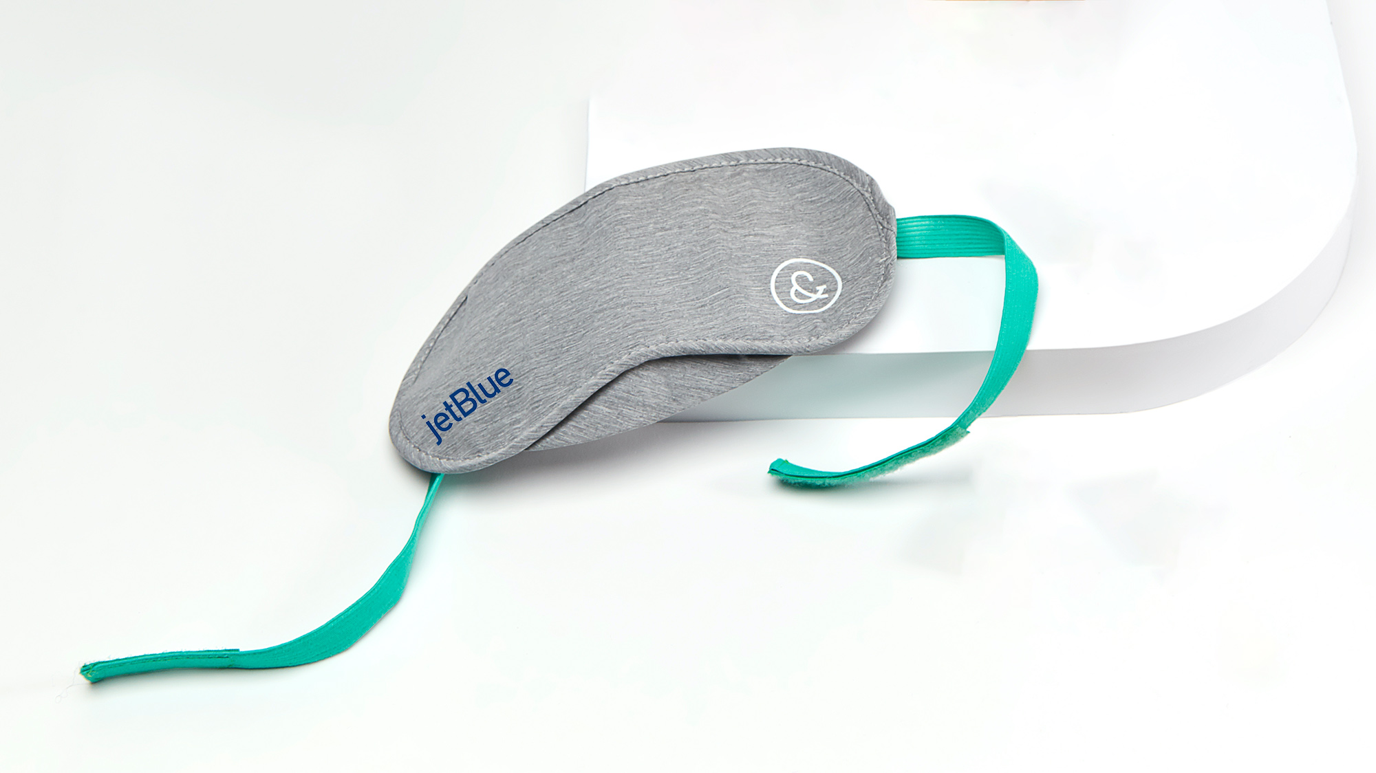 a grey eye mask with a green strap