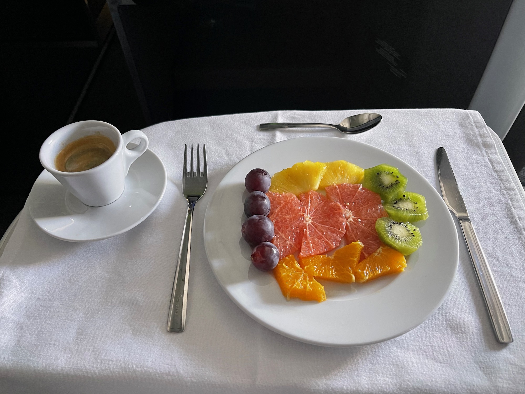 a plate of fruit and a cup of coffee