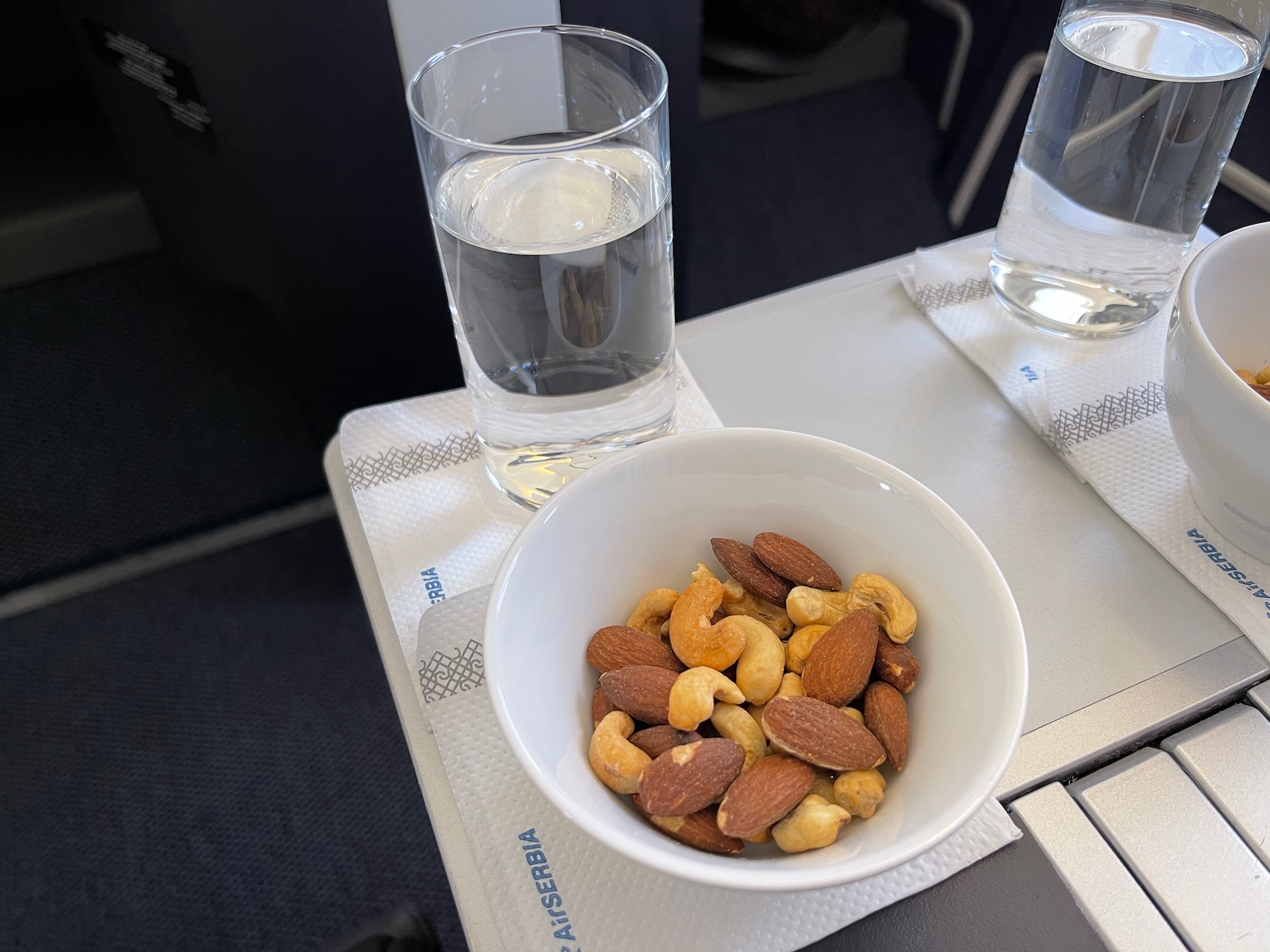 a bowl of nuts and a glass of water