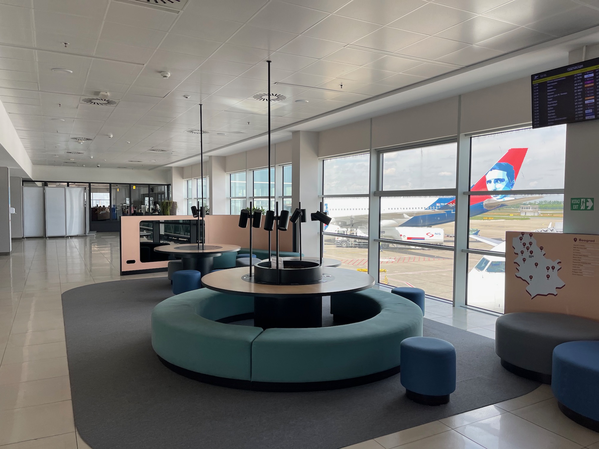 a room with a round table and blue benches