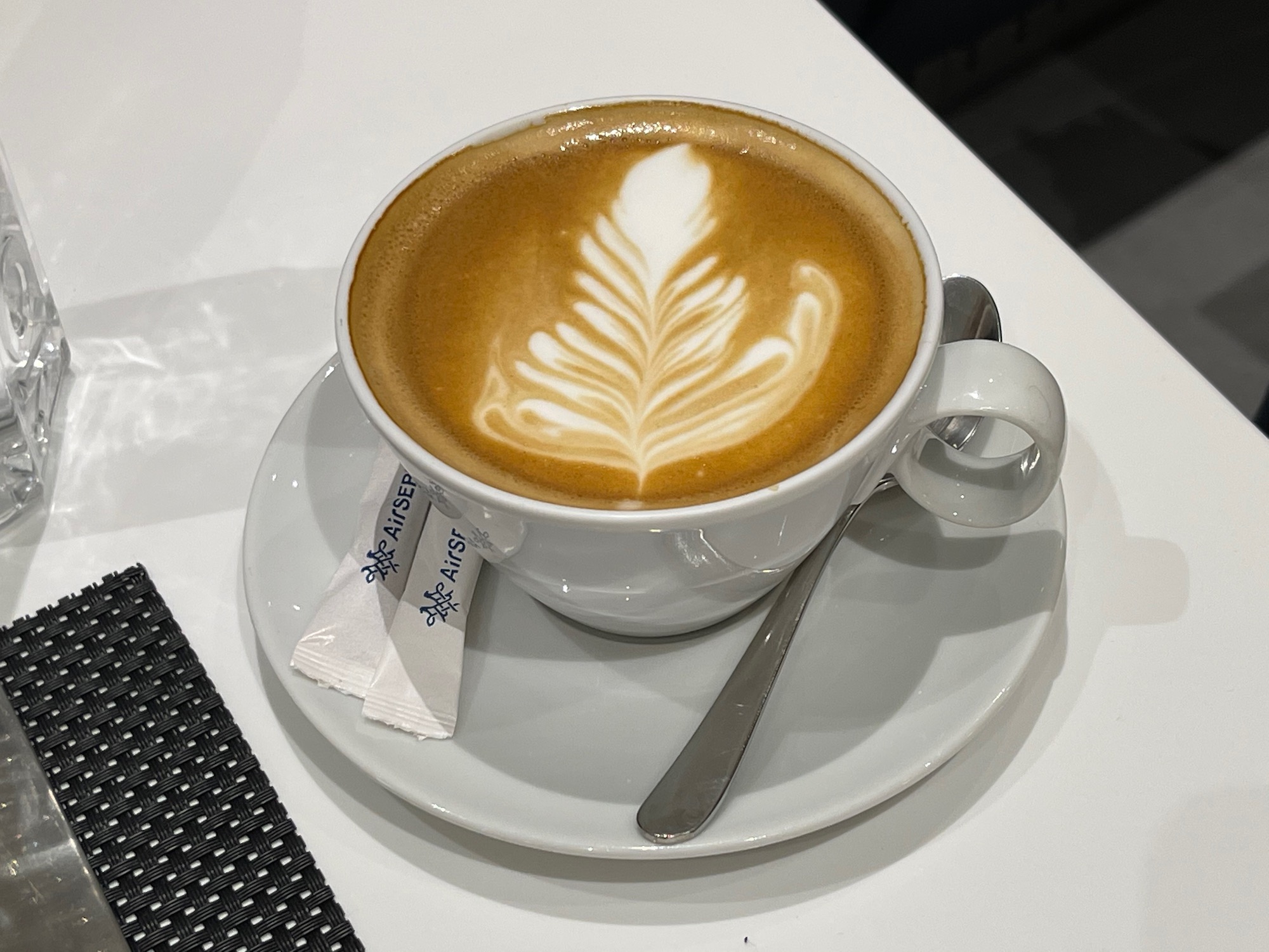 a cup of coffee with a leaf design in the foam