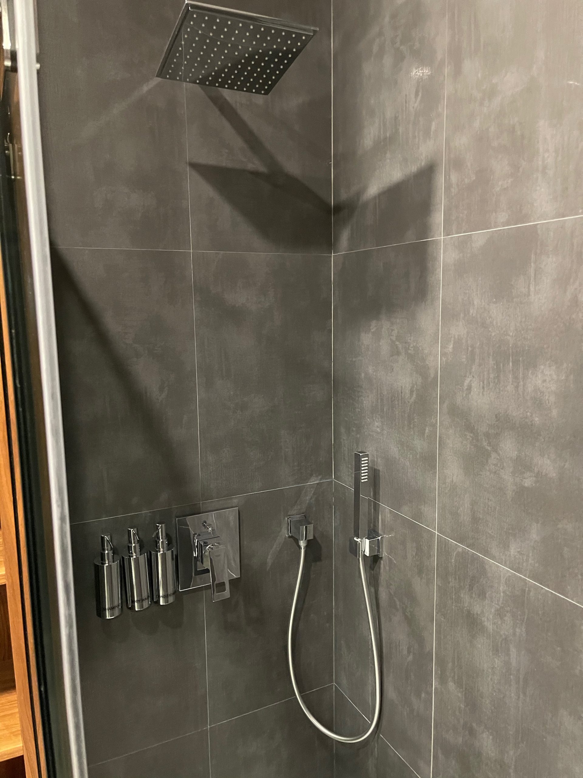 a shower with a shower head and hose