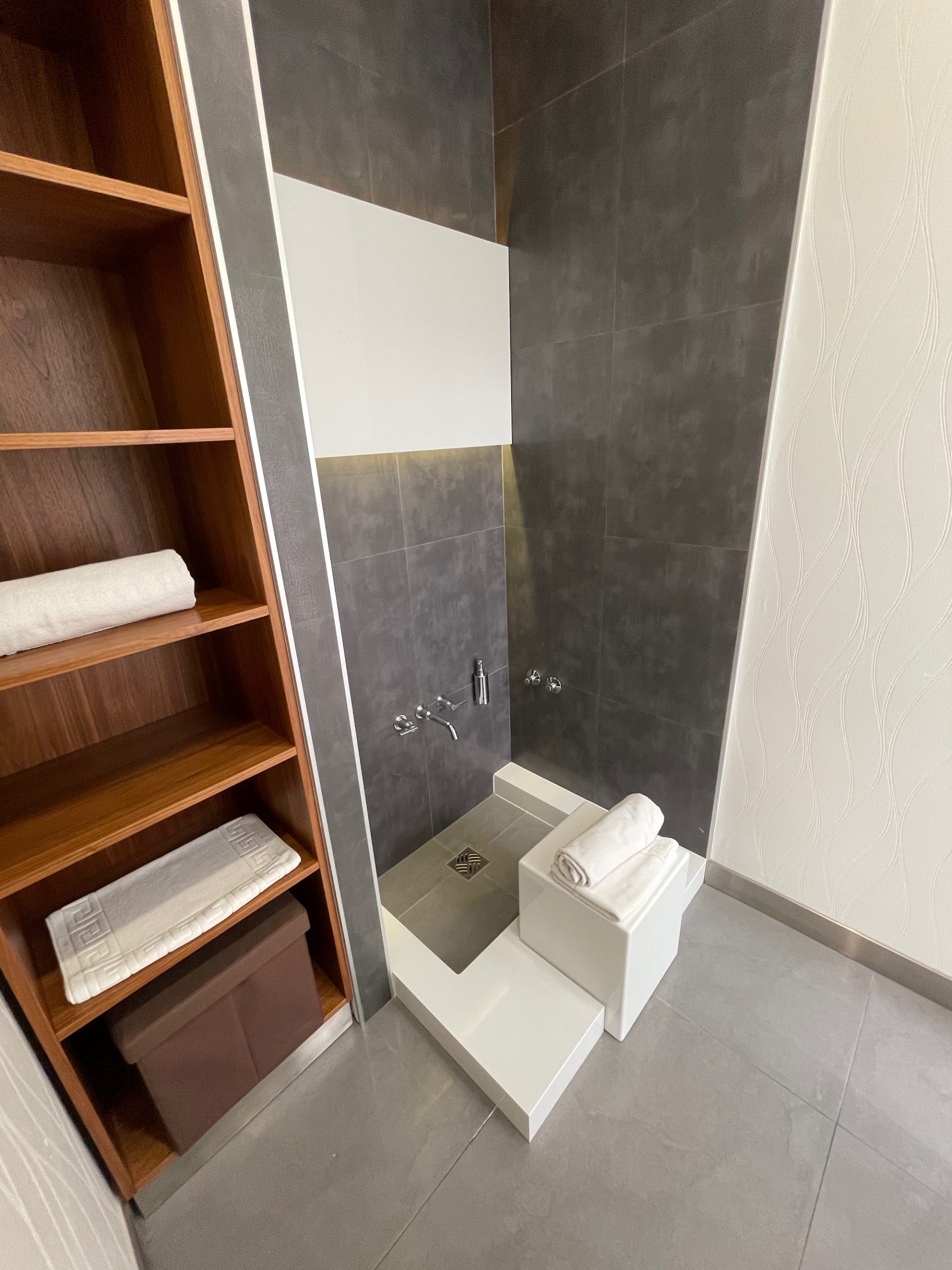 a bathroom with a shower and shelves