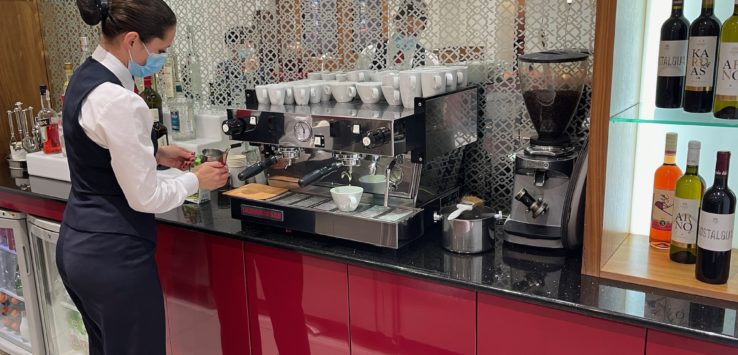 a woman making coffee at a coffee machine