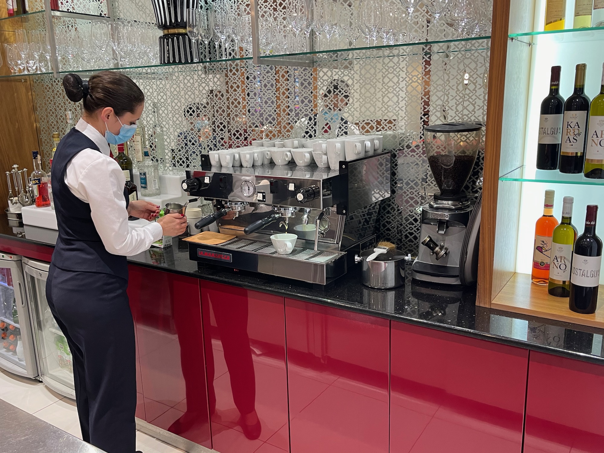 a woman making coffee at a coffee machine