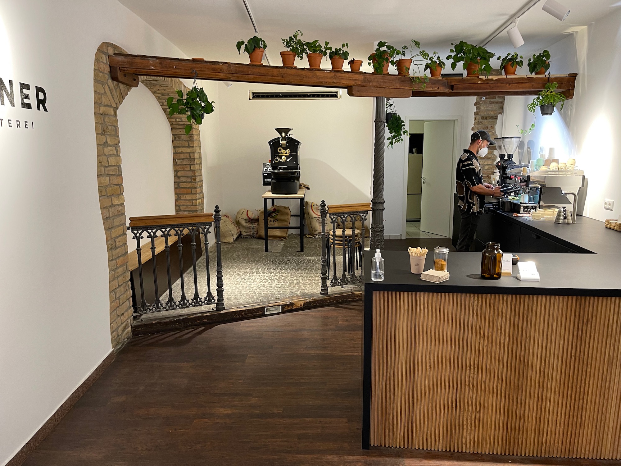 a room with a wood floor and a wood counter with a man standing behind it