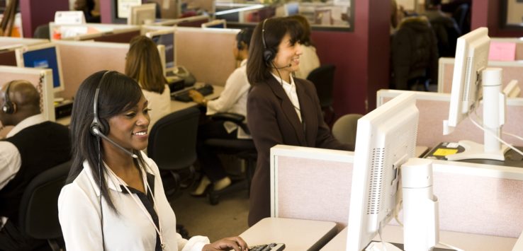 a woman wearing headset and sitting at a computer