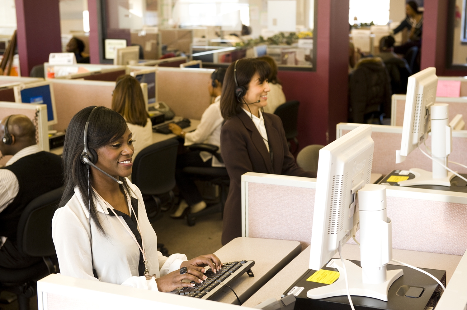 a woman wearing headset and sitting at a computer