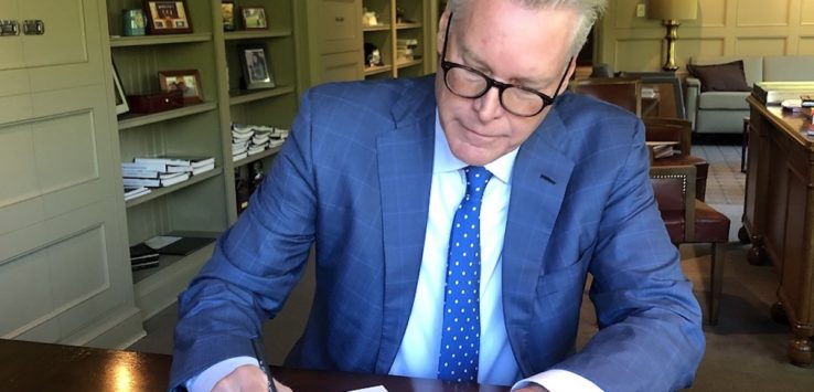 a man in a suit writing on a piece of paper