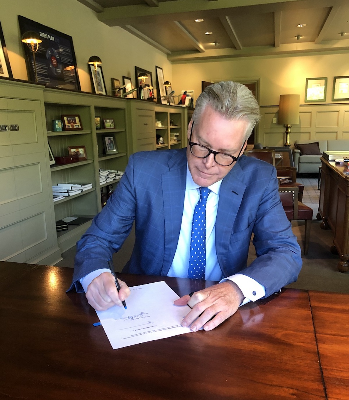 a man in a suit writing on a piece of paper