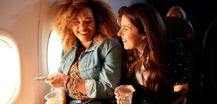 two women sitting on an airplane