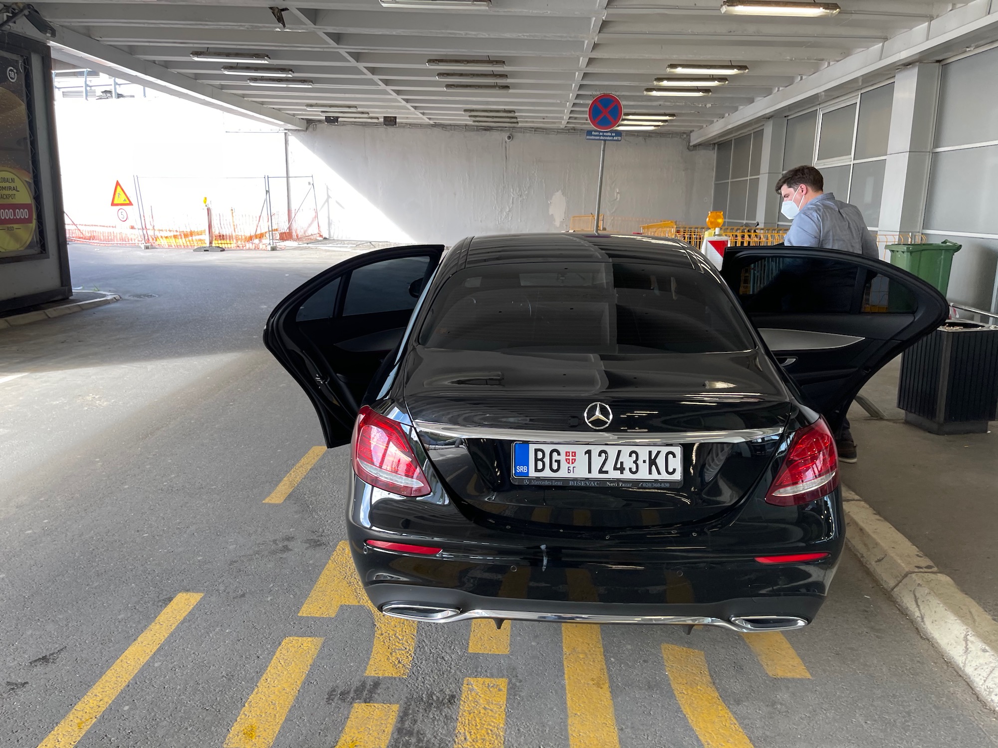 a man standing in a parking lot with a car