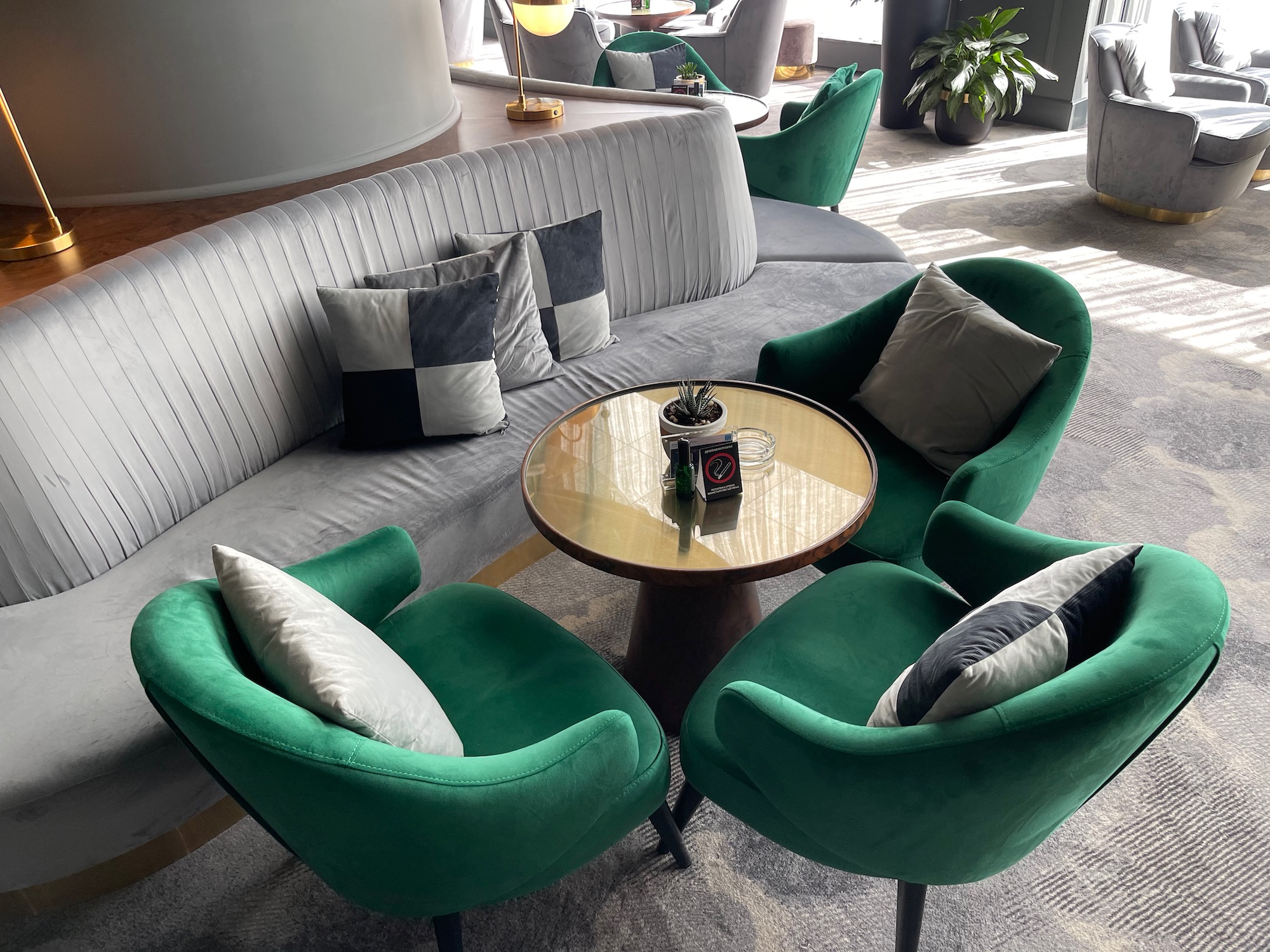 a group of green chairs and a round table in a room