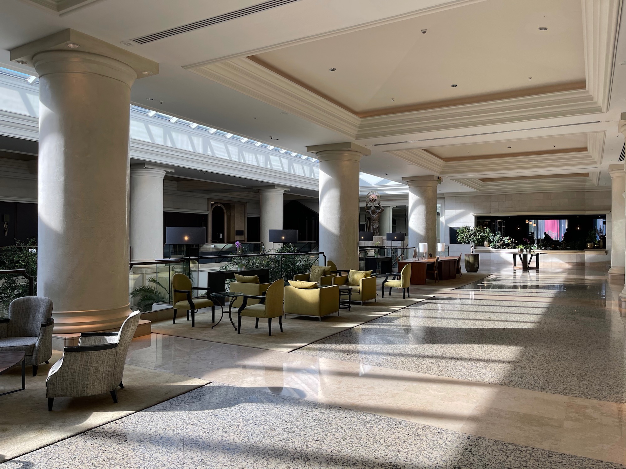 a large lobby with a glass roof and chairs