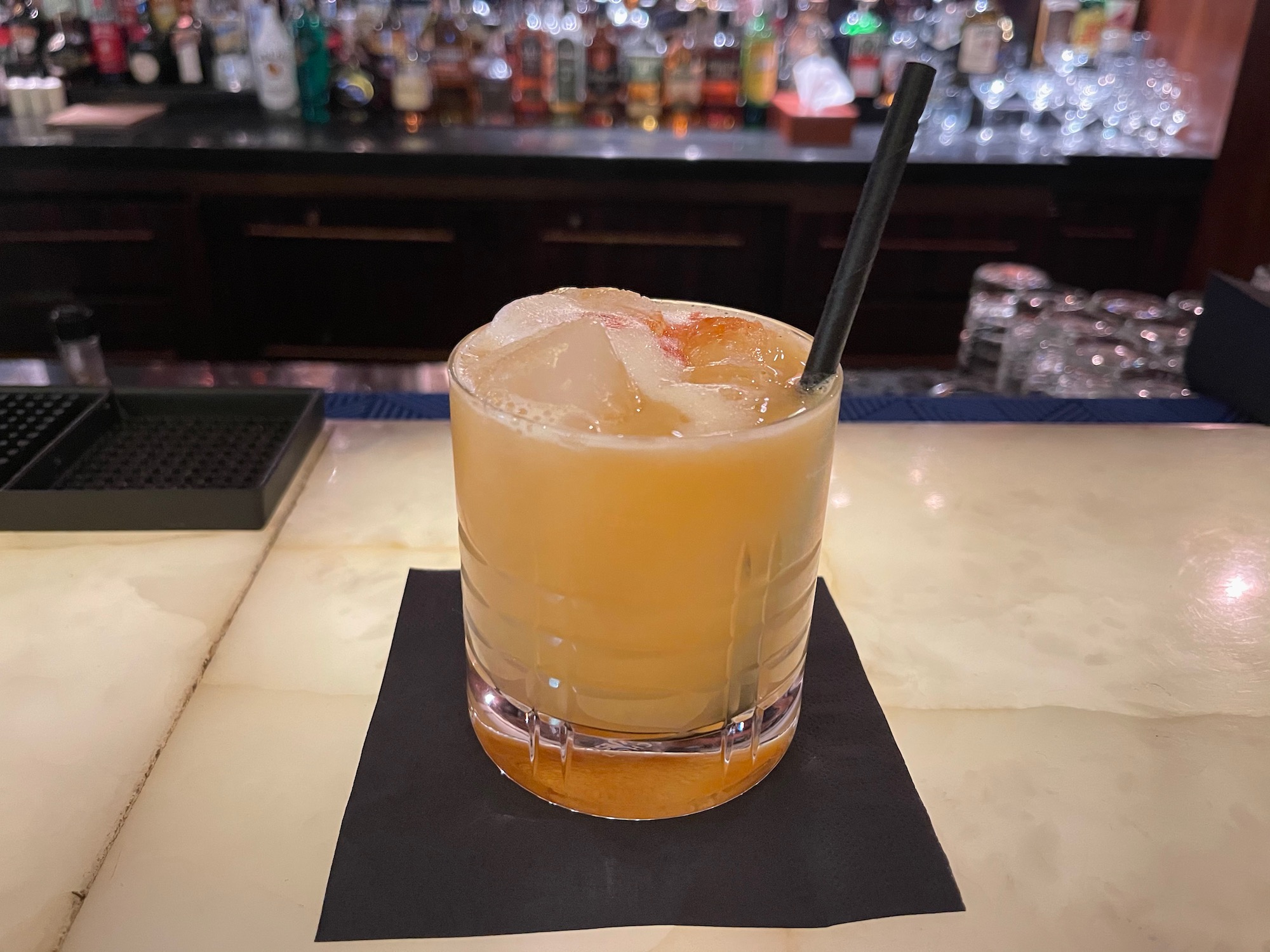 a glass of orange liquid with a straw