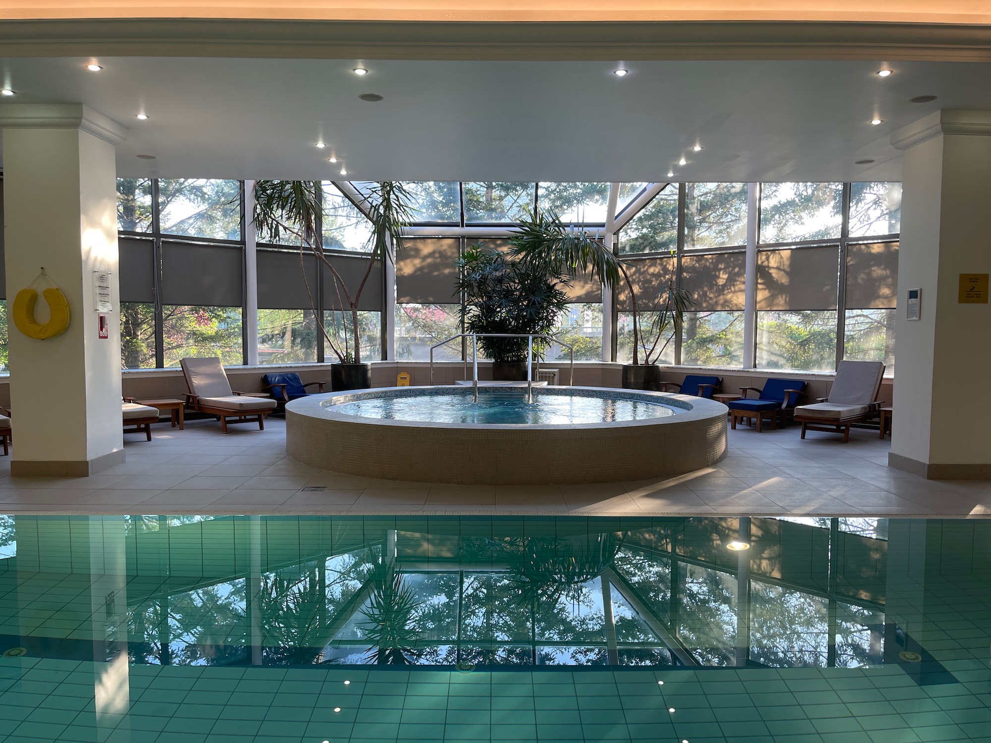 a indoor pool with a large round tub and a large window