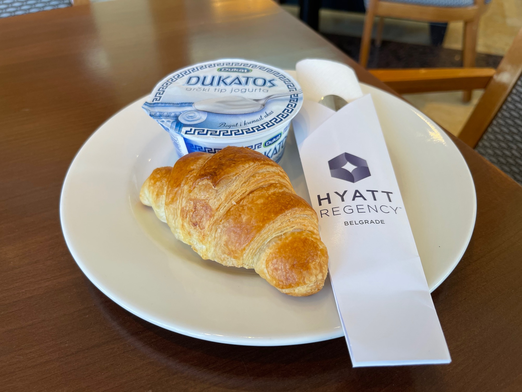 a croissant and a bowl of yogurt on a plate