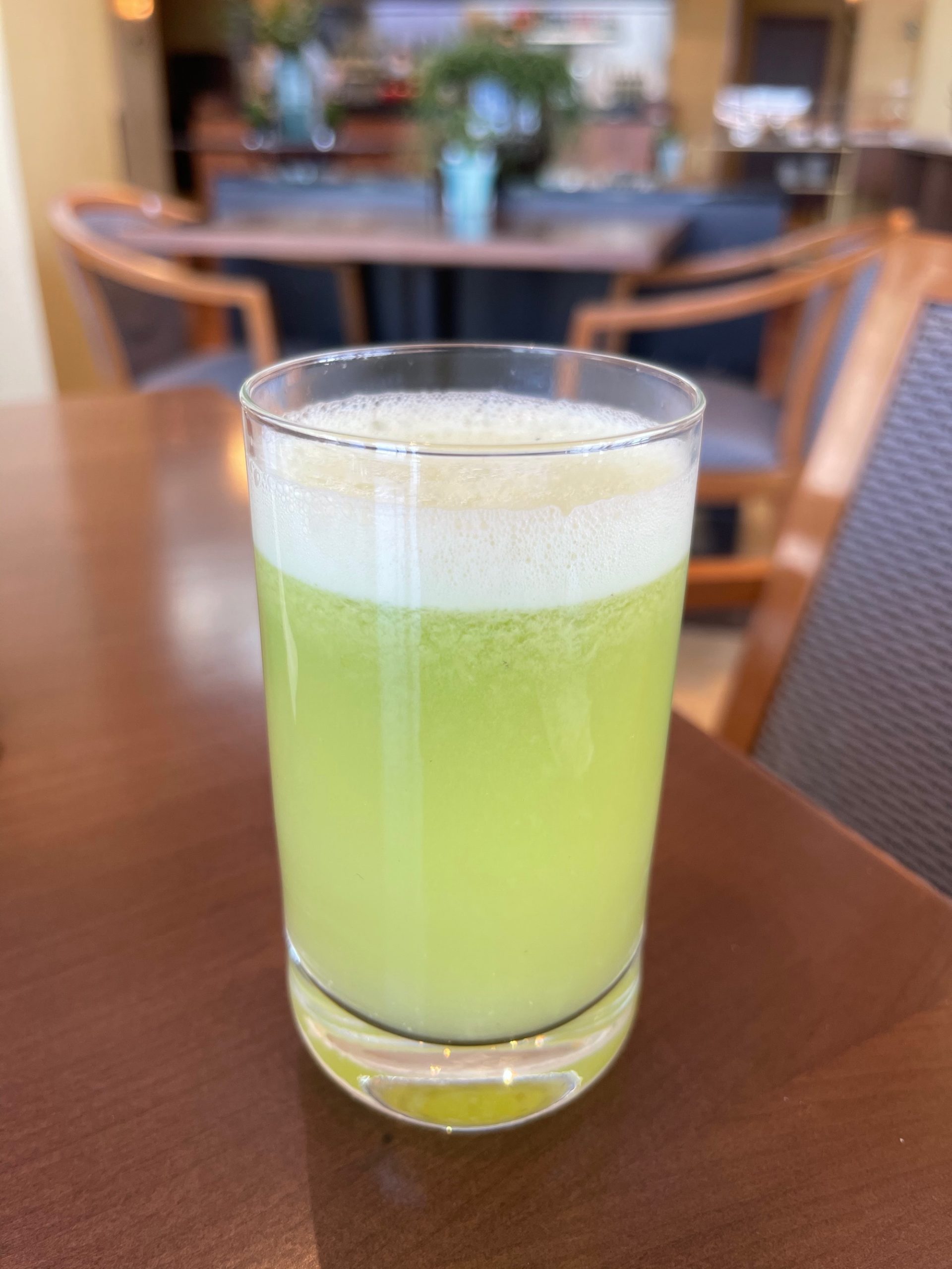 a glass of green liquid on a table