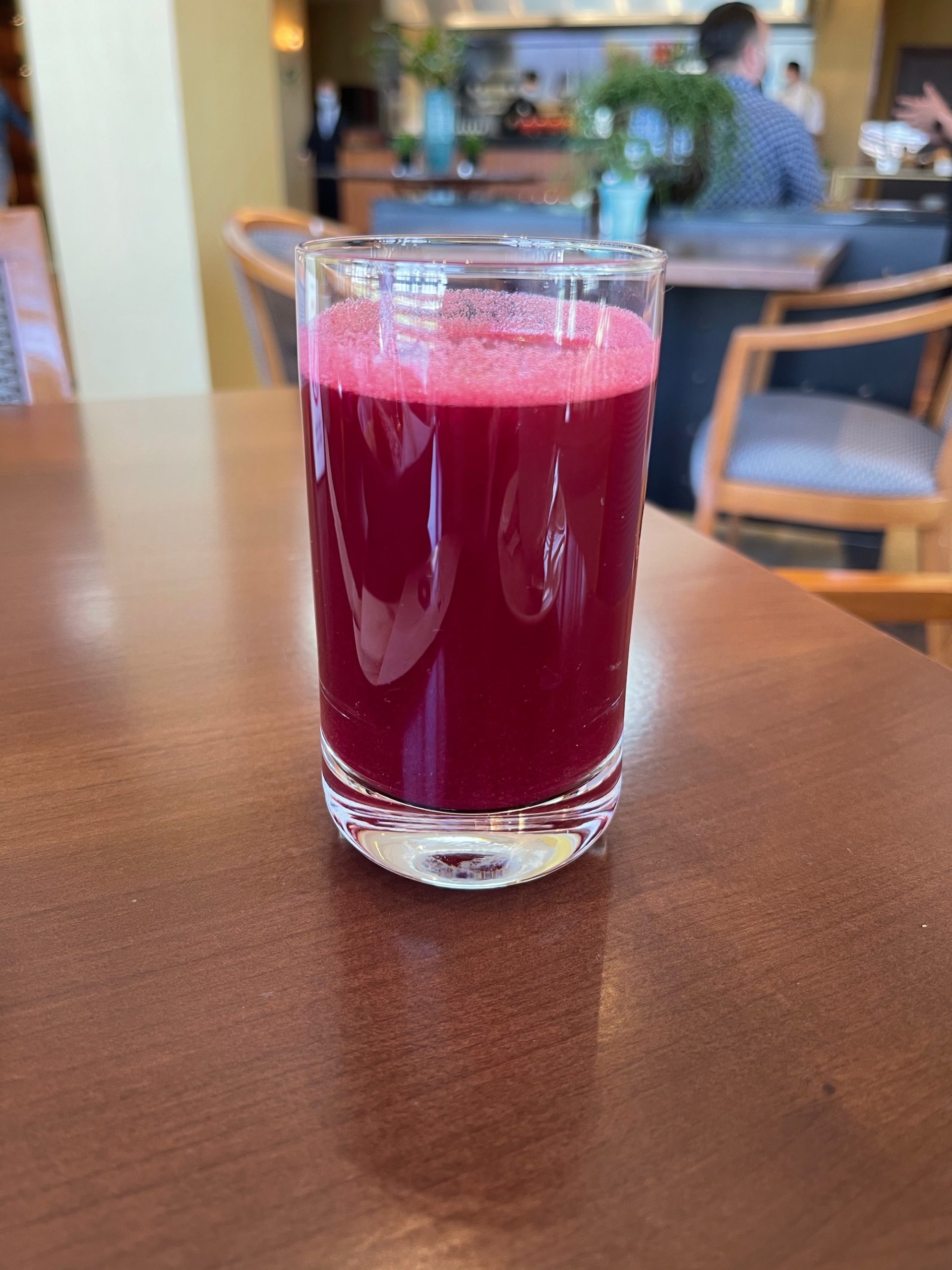 a glass of red liquid on a table