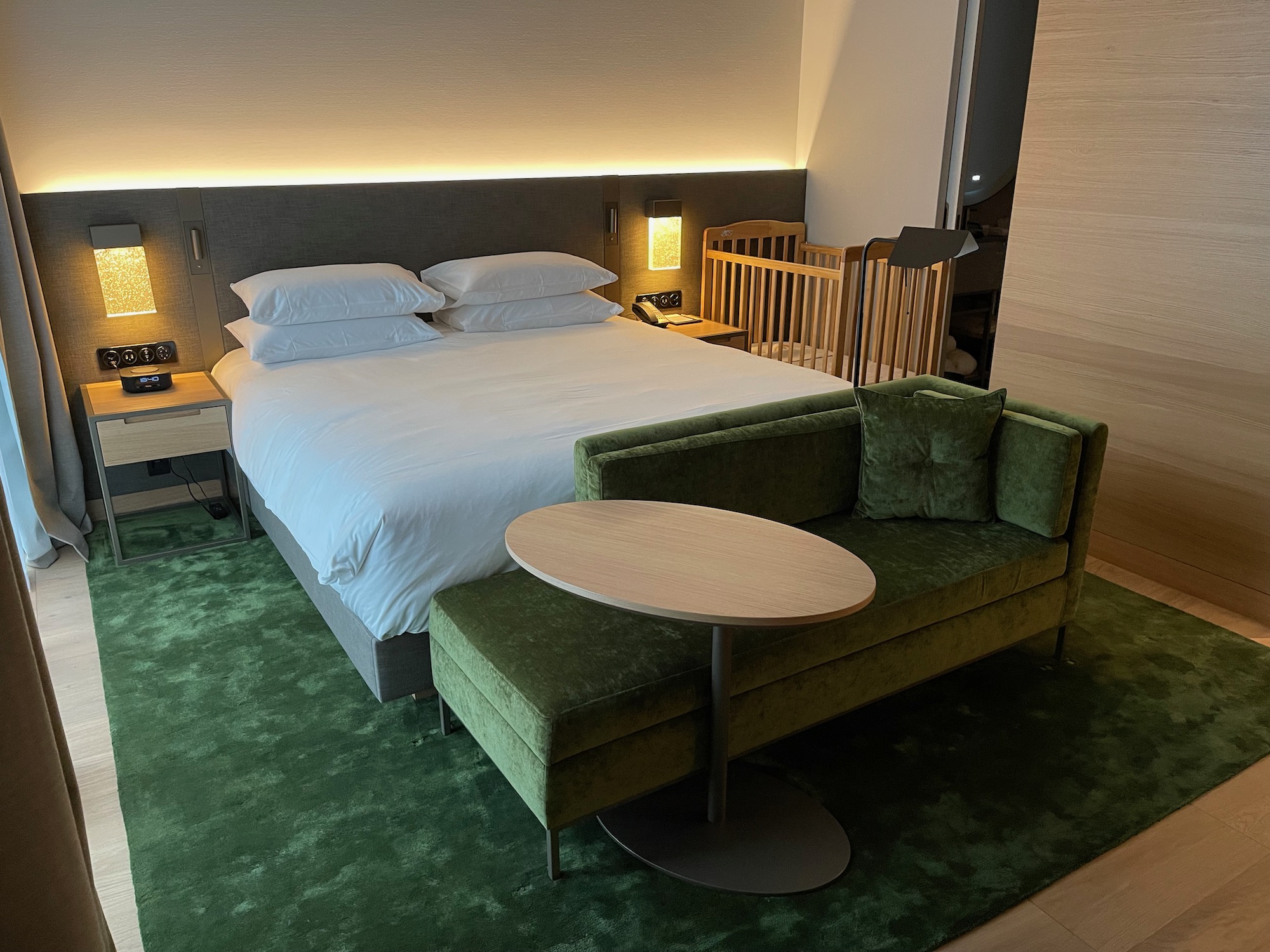 a bed with a green couch and a round table