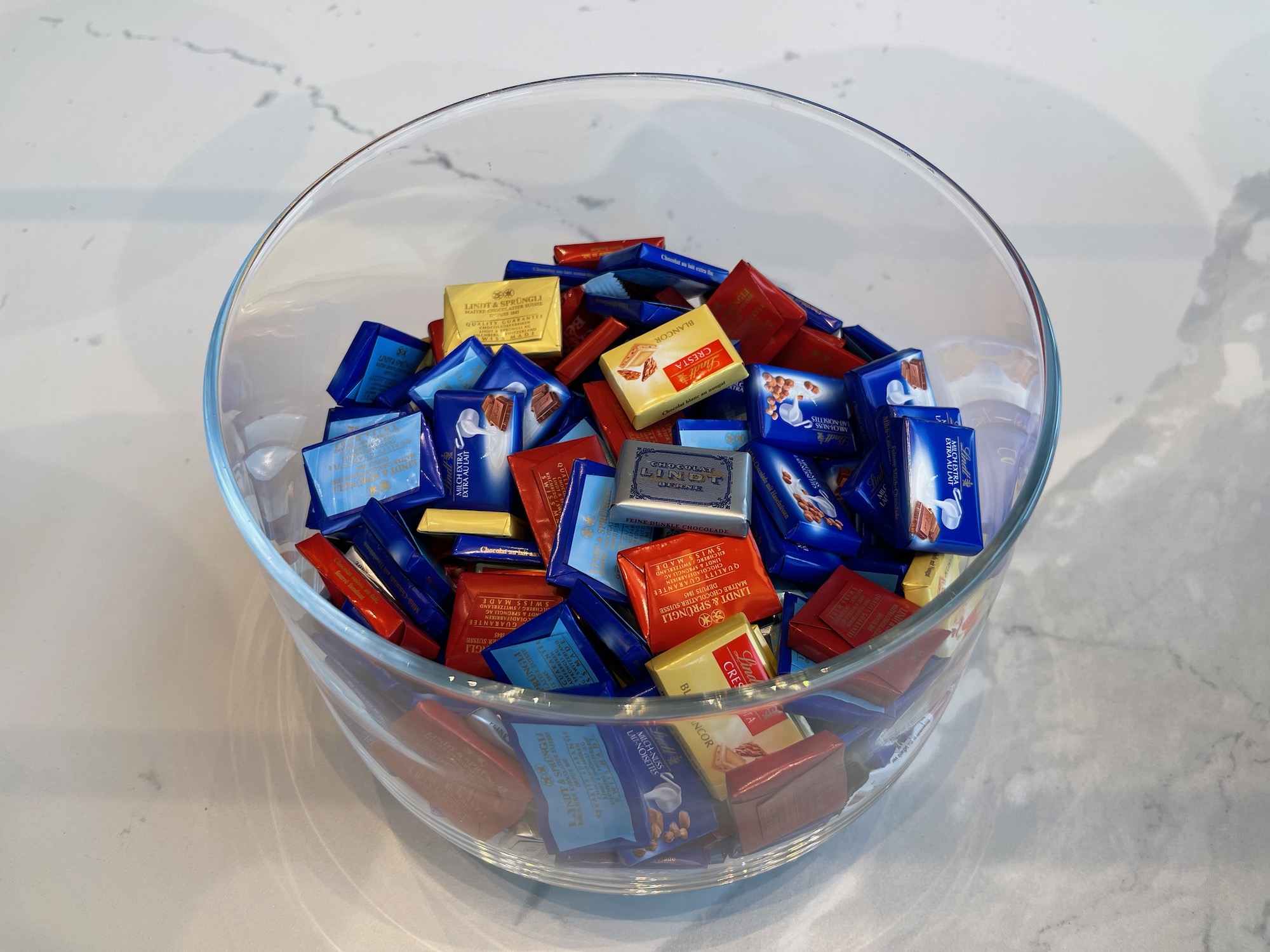 a bowl of candy wrapped in different colors