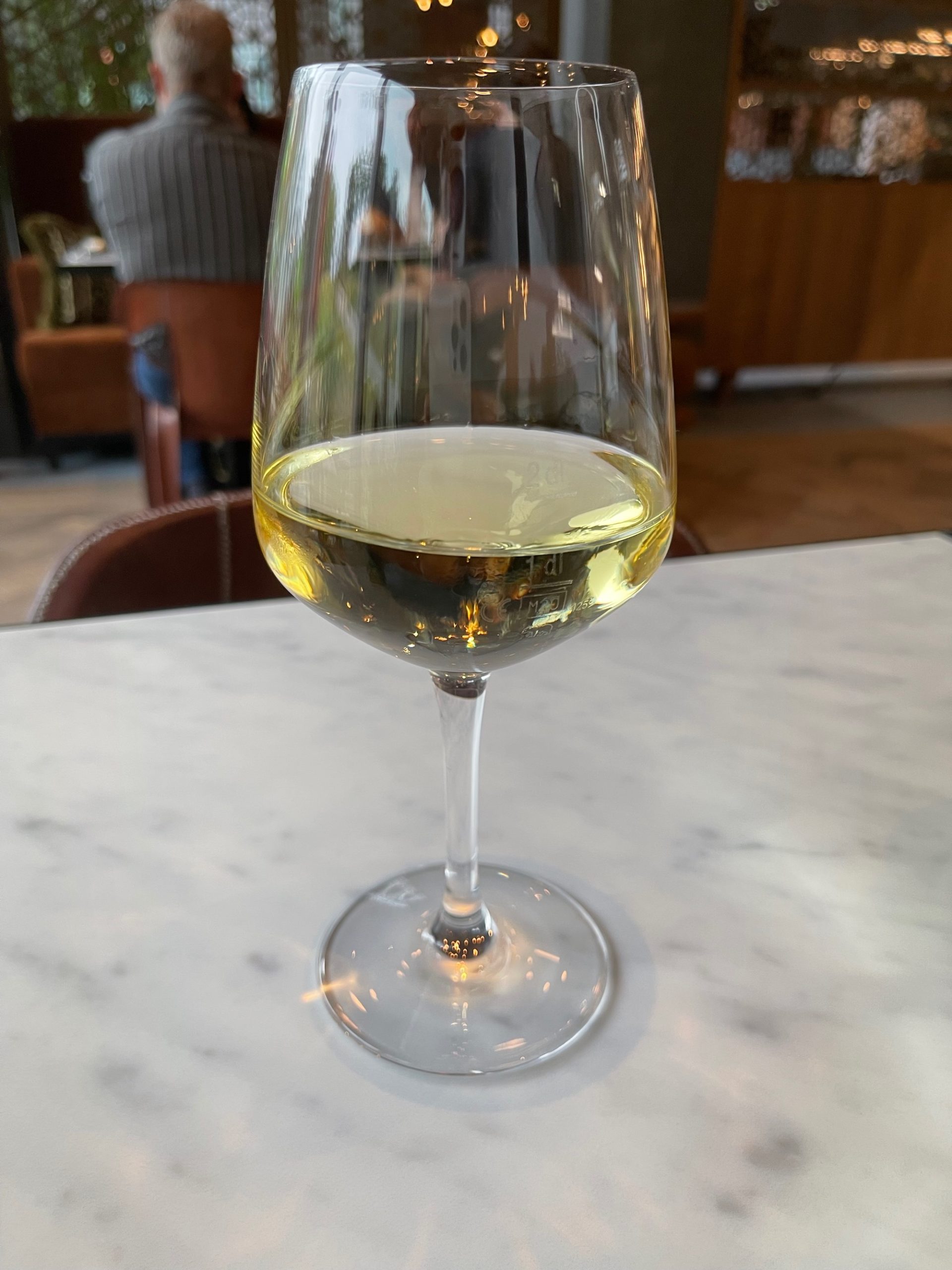 a glass of white wine on a table