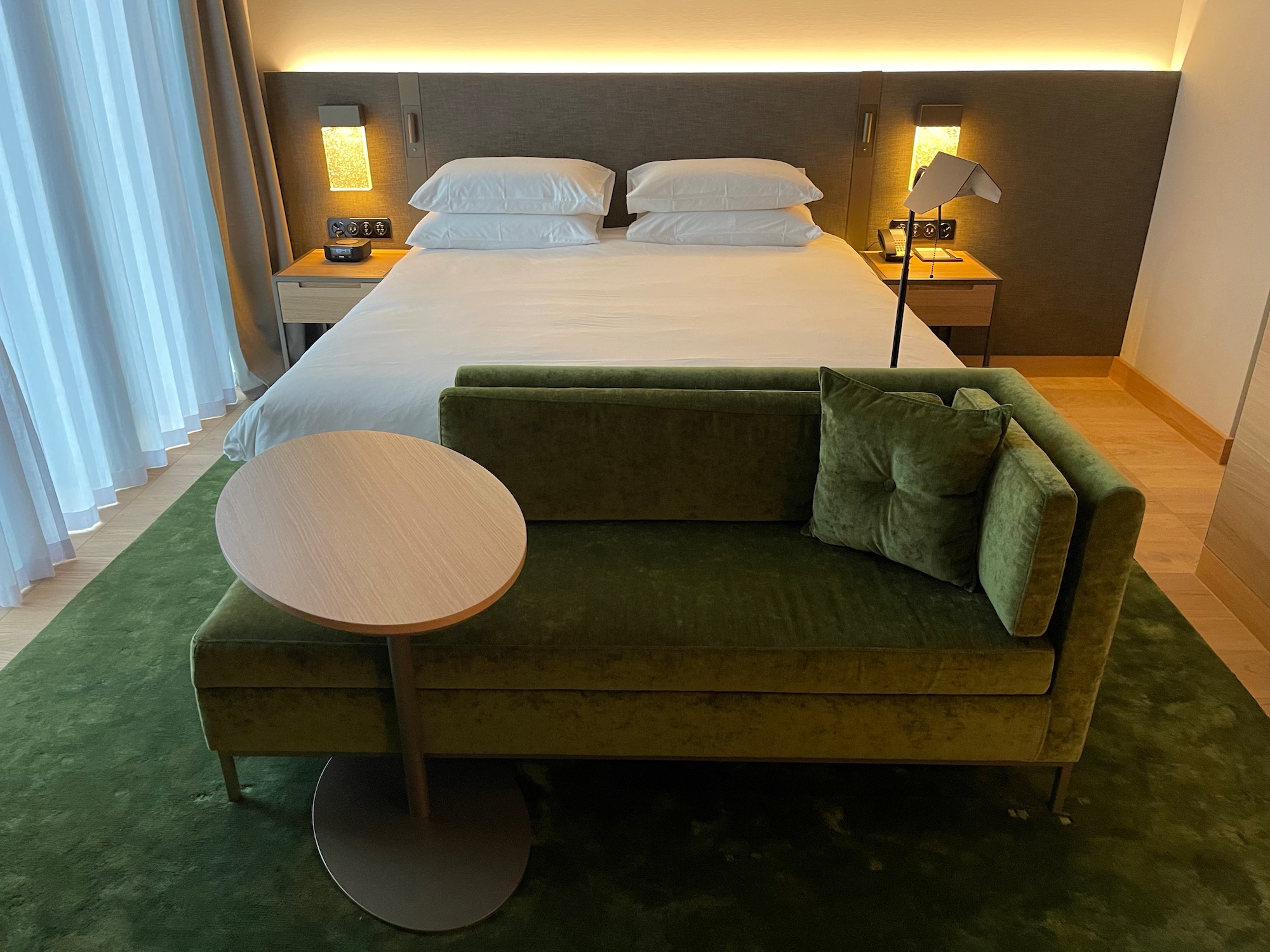 a bed with a green couch and a table