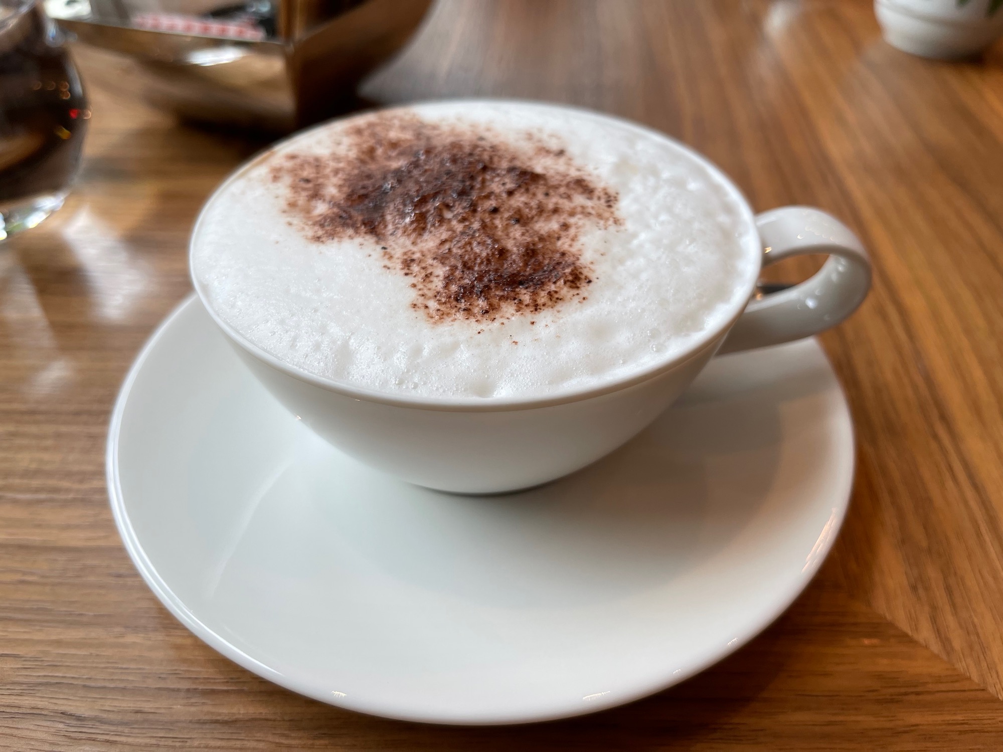 a white cup with foam and brown powder on top