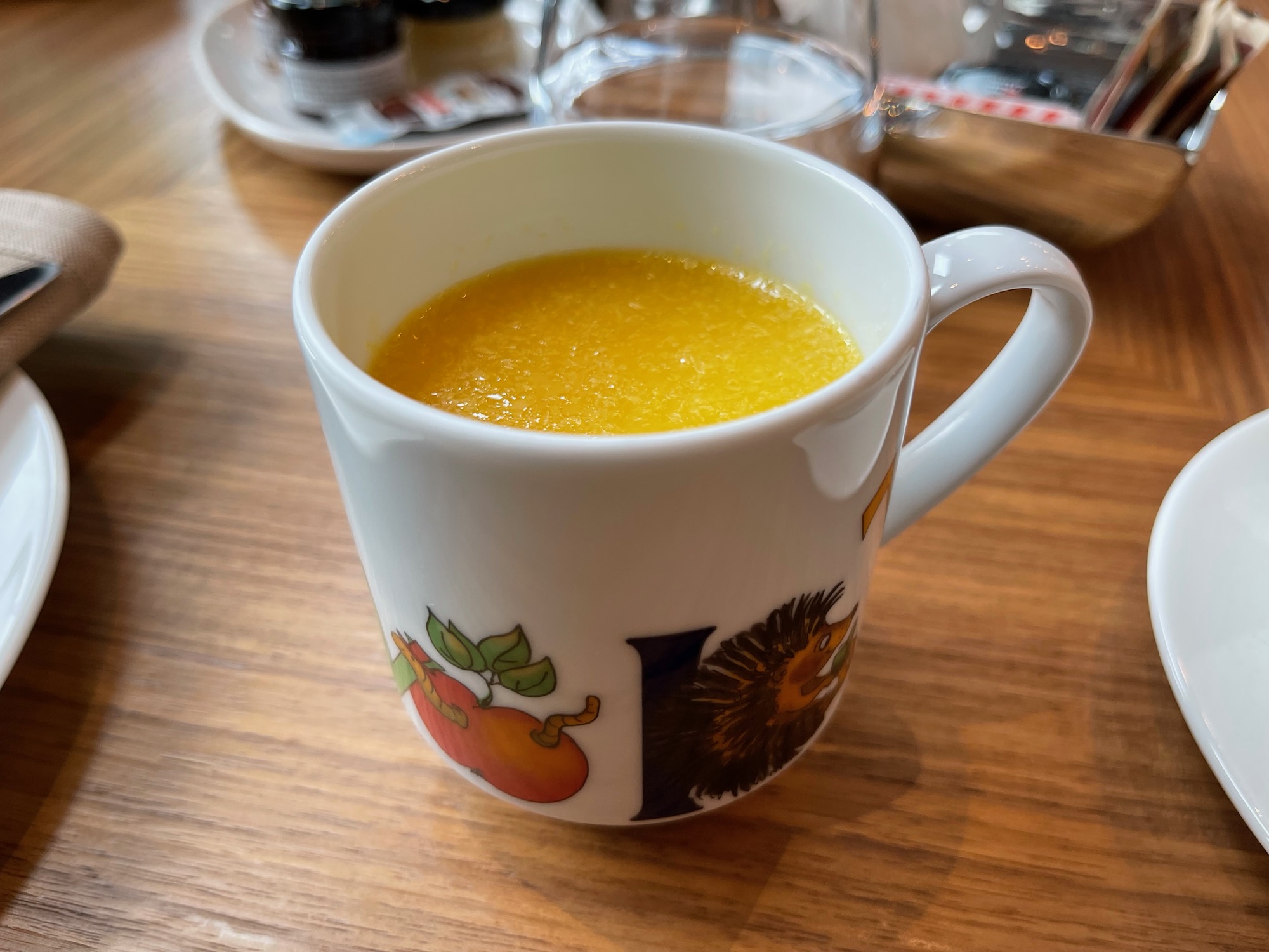 a white mug with yellow liquid in it