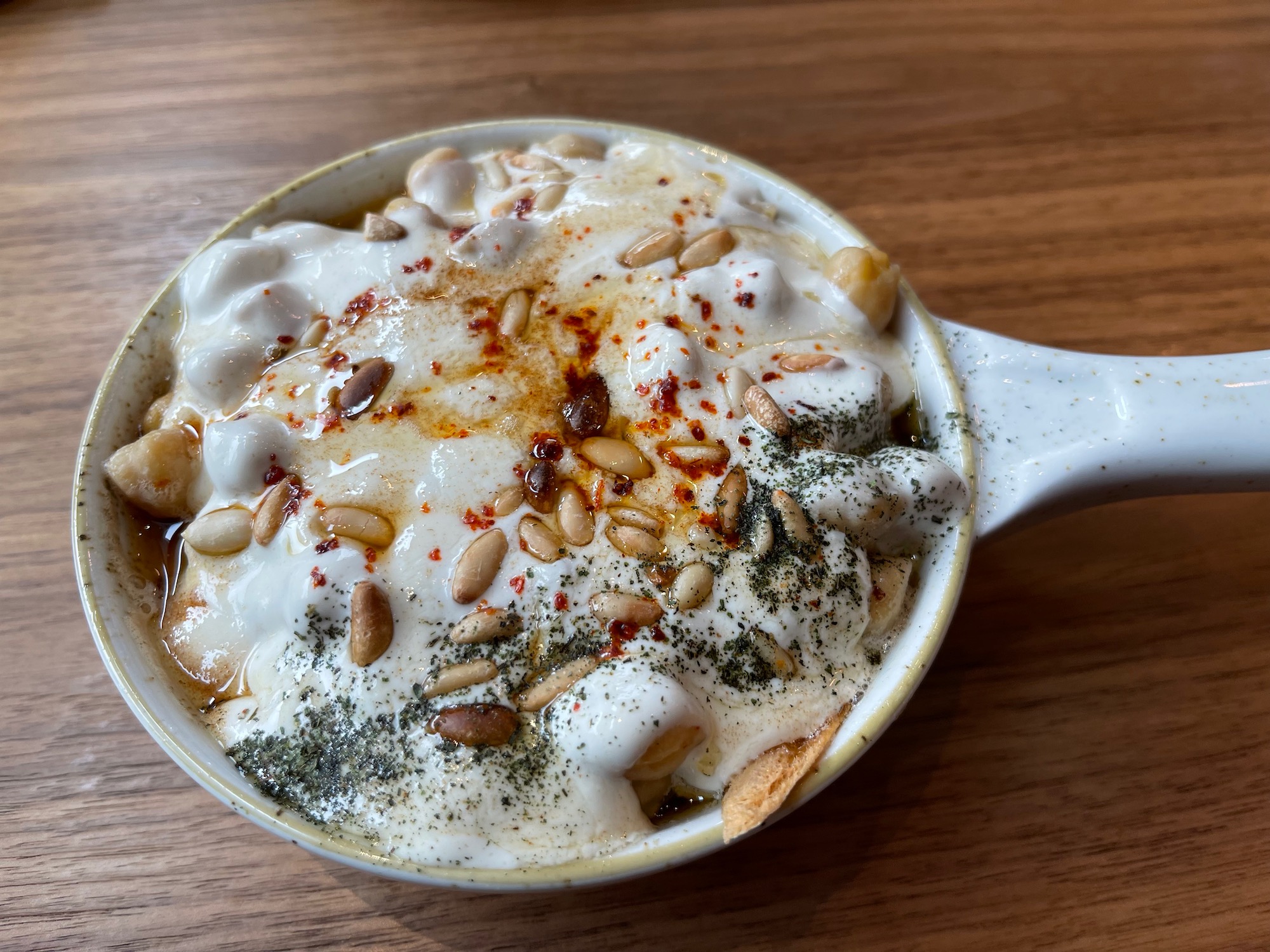 a bowl of soup with white sauce and spices