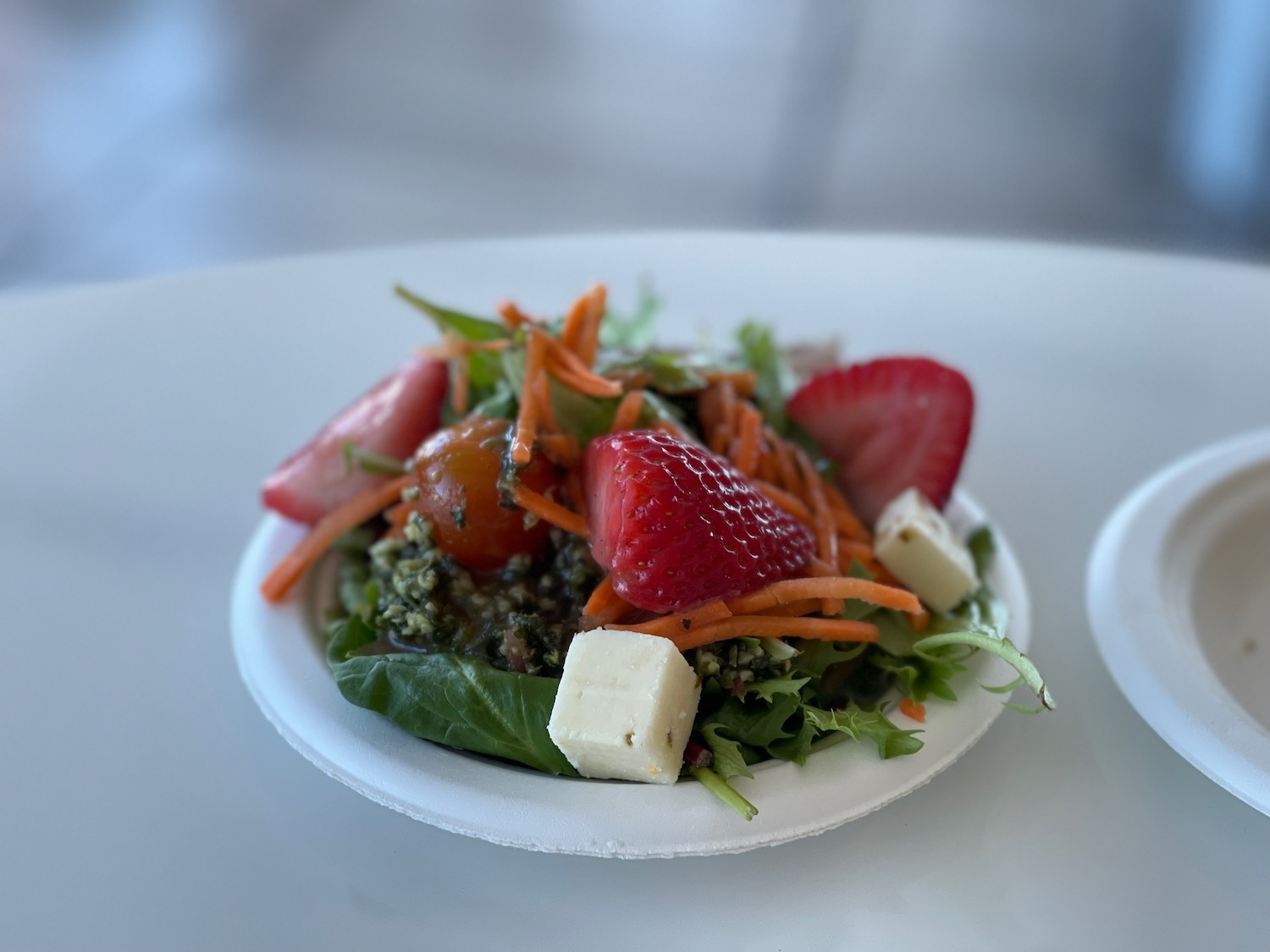 a plate of salad with strawberries and cheese