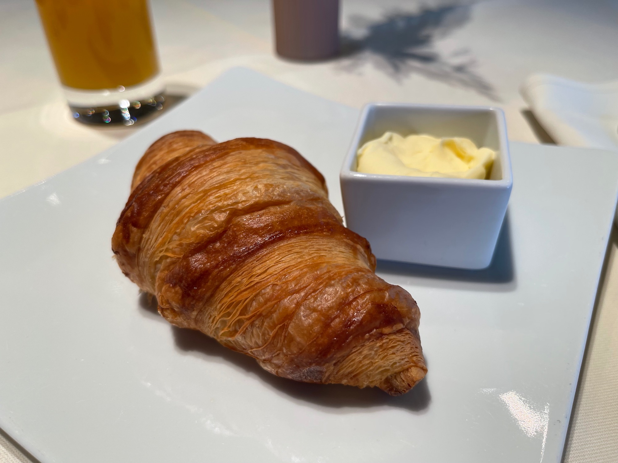 a croissant and butter on a plate