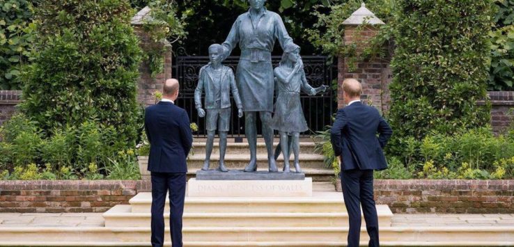 a group of people standing in front of a statue