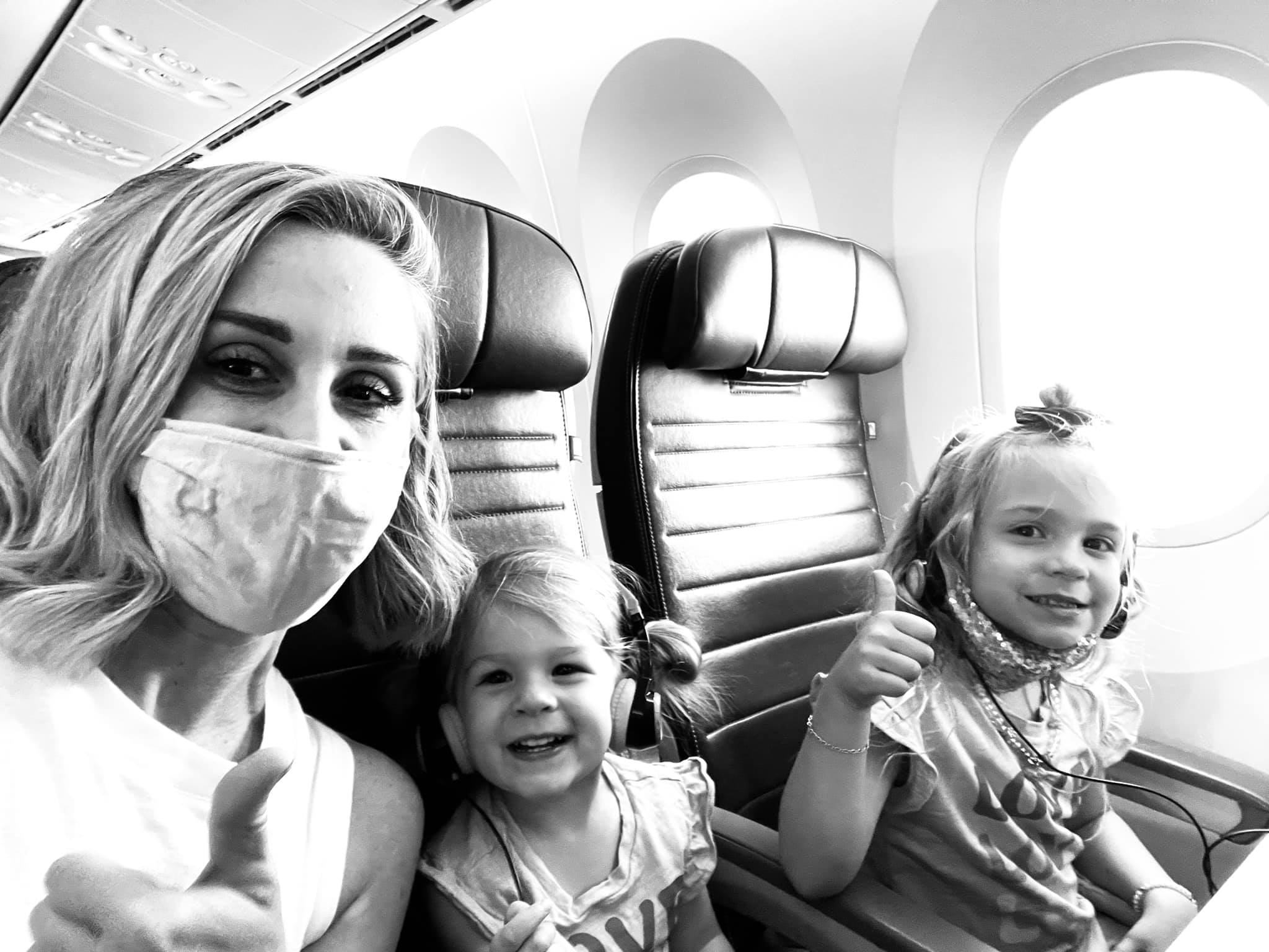 a woman and two girls on an airplane