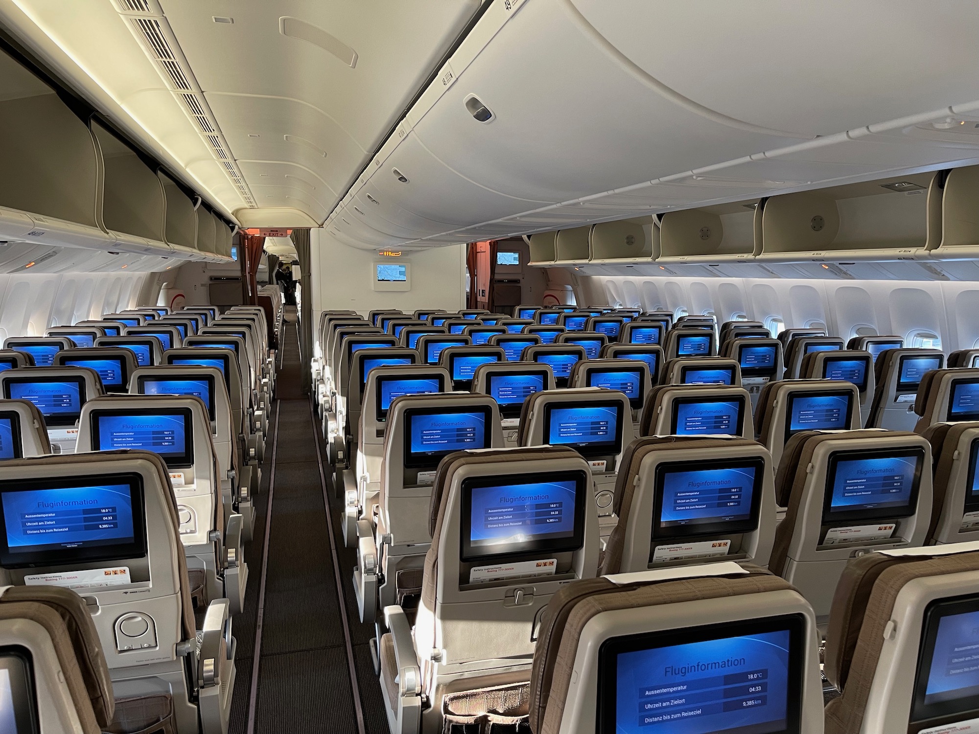 an airplane with rows of seats and monitors