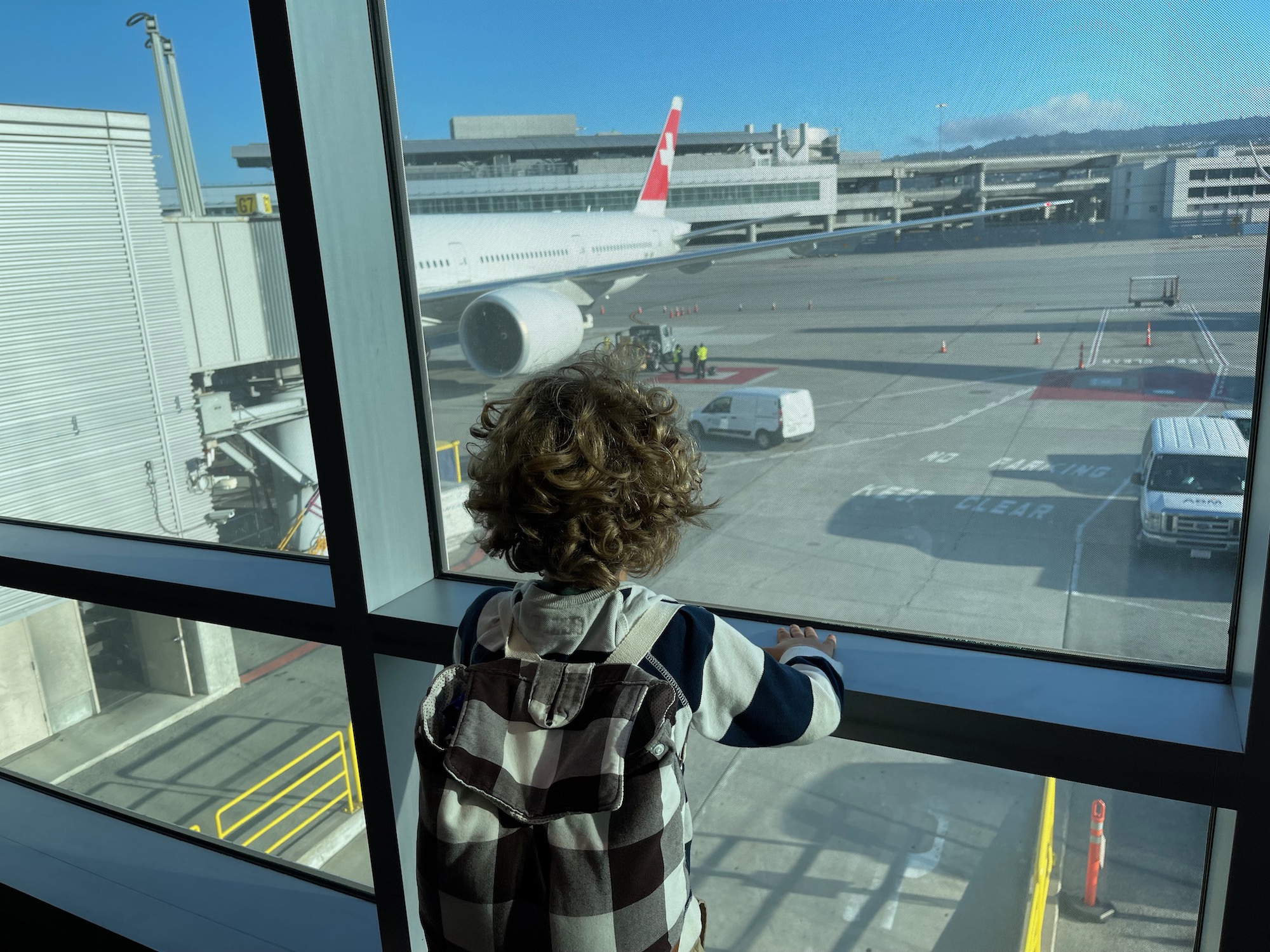 a child looking out a window at an airport