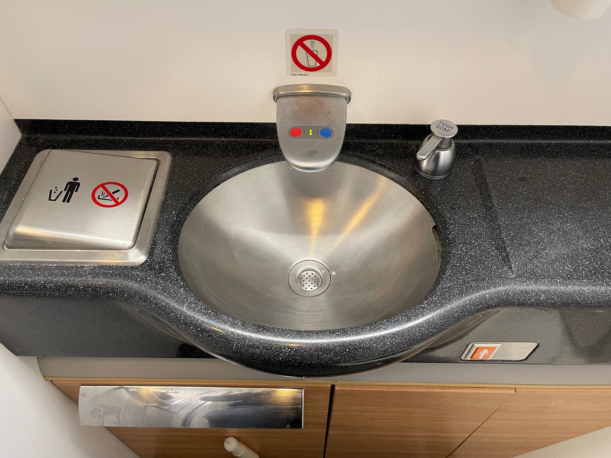 a sink with a faucet and a no smoking sign