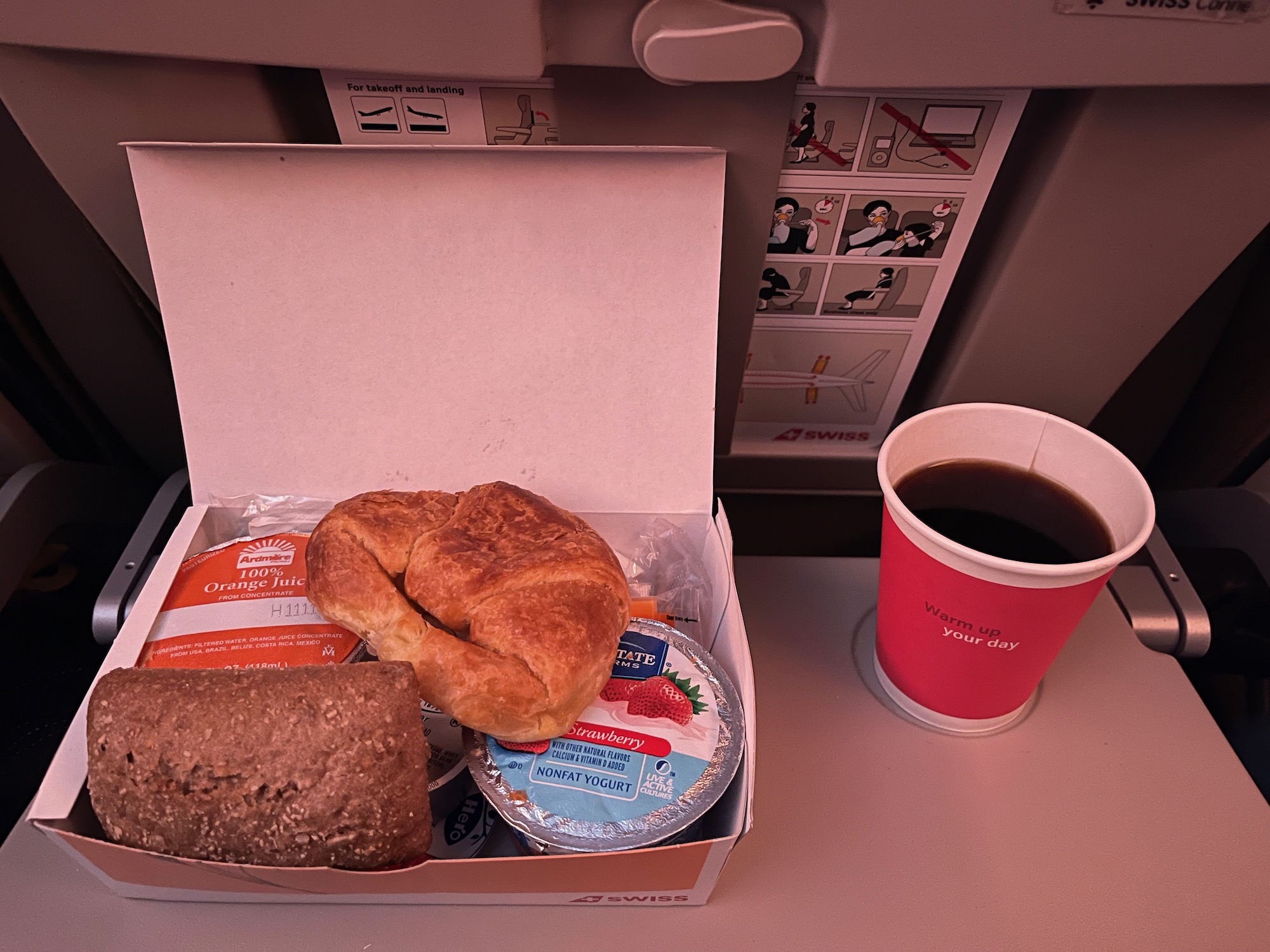 a box of food and a cup of coffee on a table