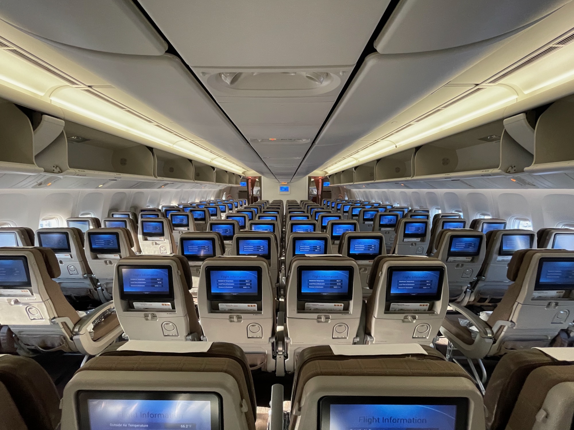 an airplane with rows of seats and monitors