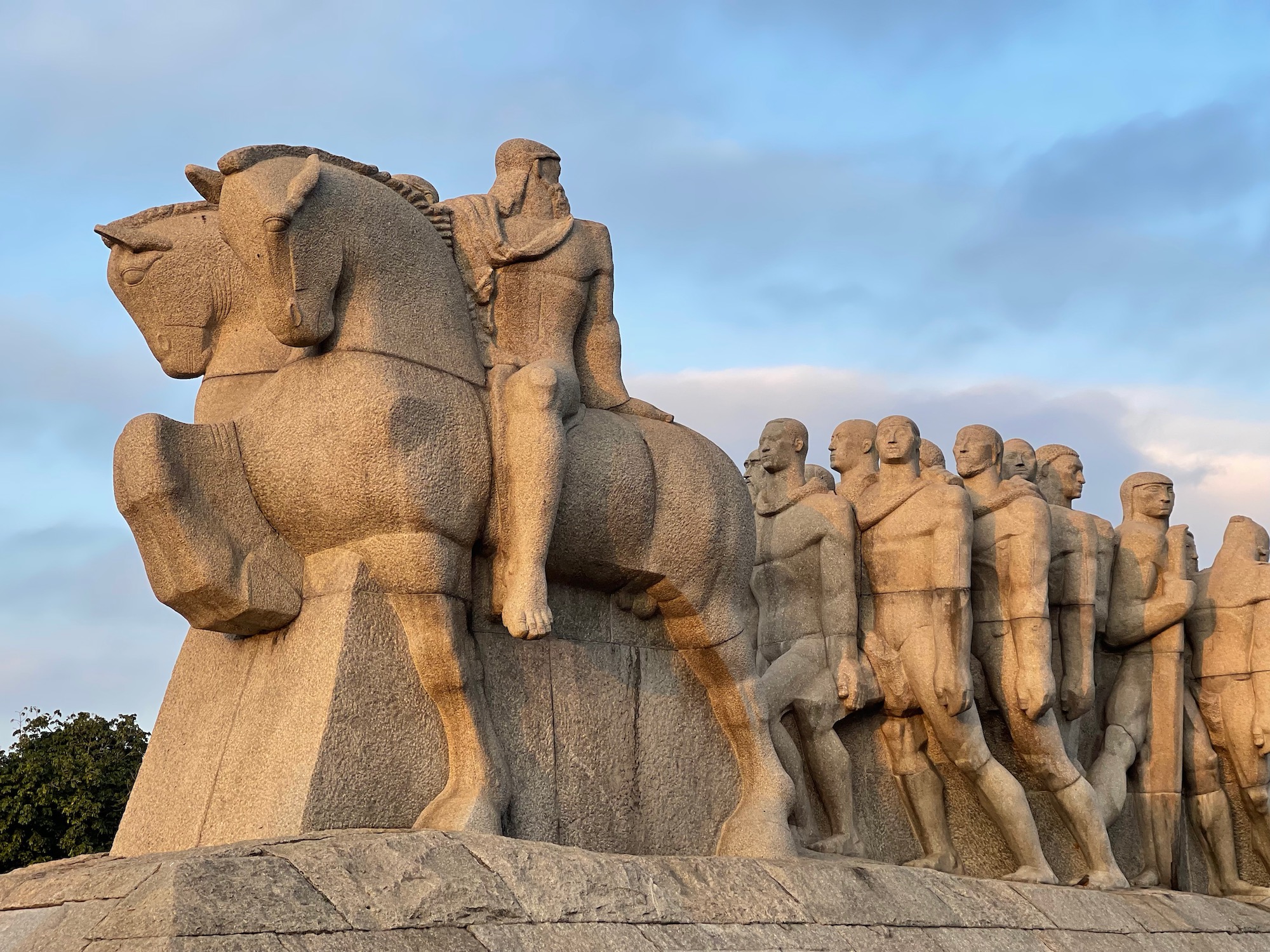 a stone statue of a group of men riding horses