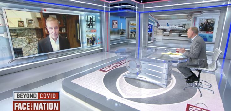 a news room with a man on the wall