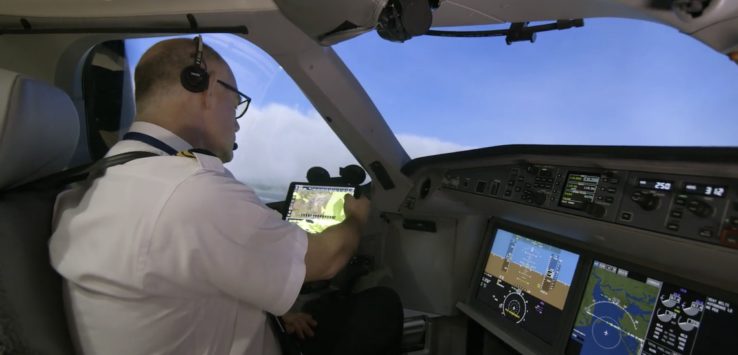 a man in a white shirt and glasses in a cockpit