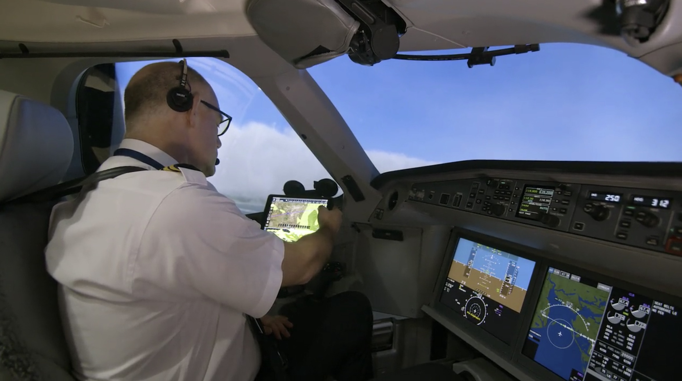 a man in a white shirt and glasses in a cockpit