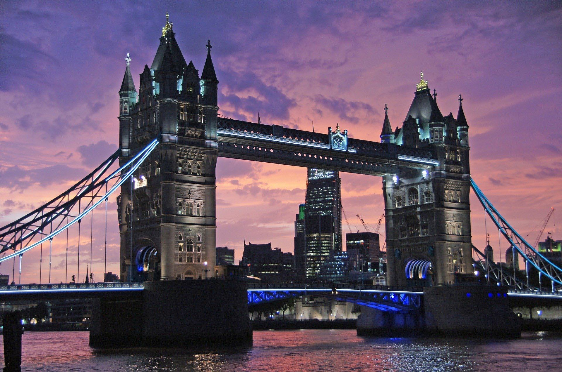 a bridge with towers and a city in the background