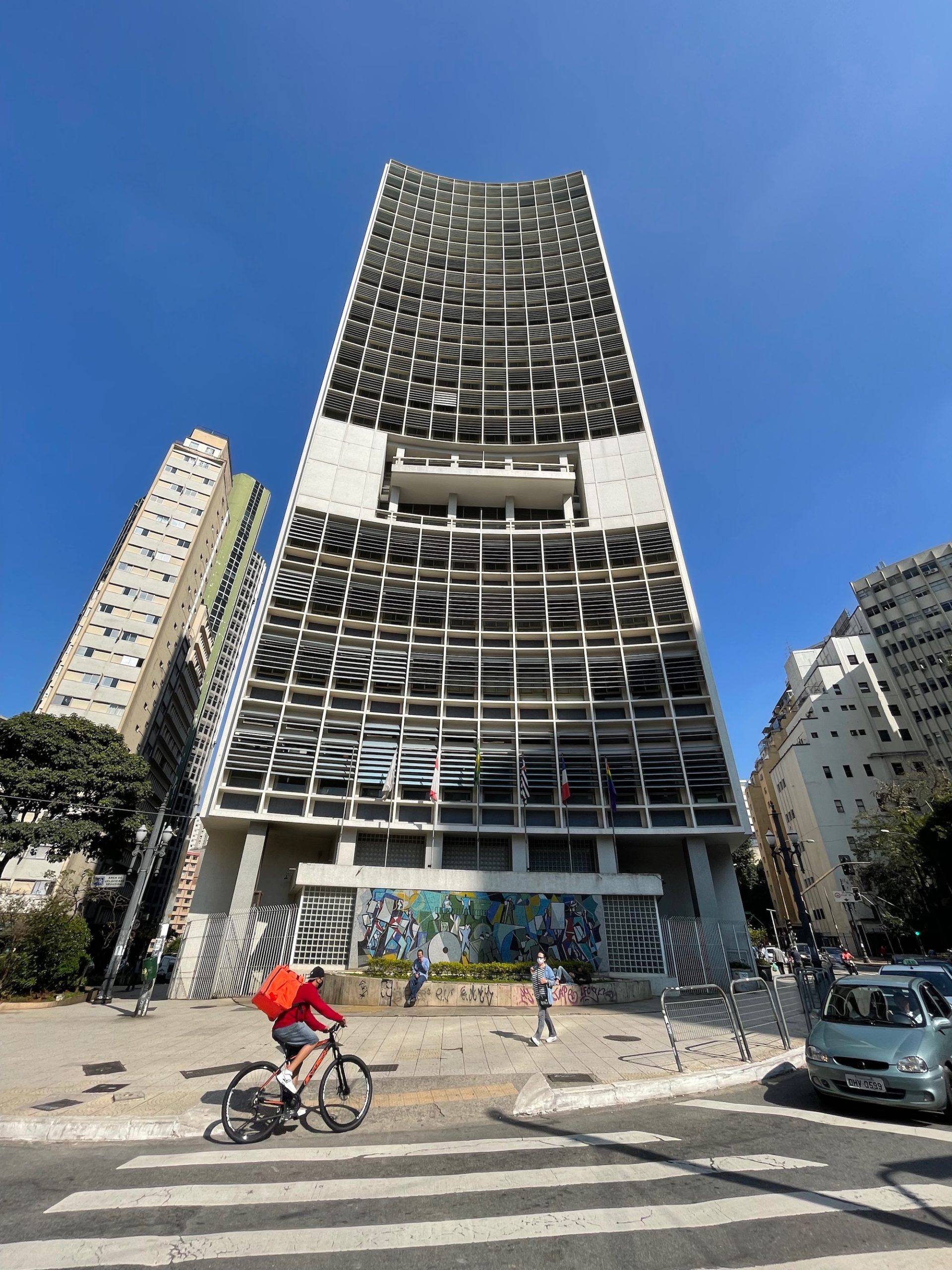 a tall building with a tall tower and people walking around